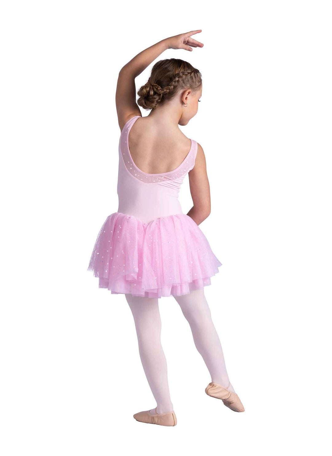 Little dancer facing backwards in a pink dress on a white background