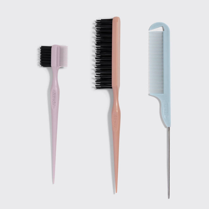 Three hairbrushes with different bristle types on a light gray background