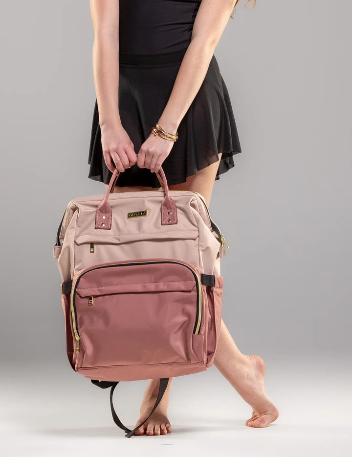 Person holding a pink backpack against a gray background