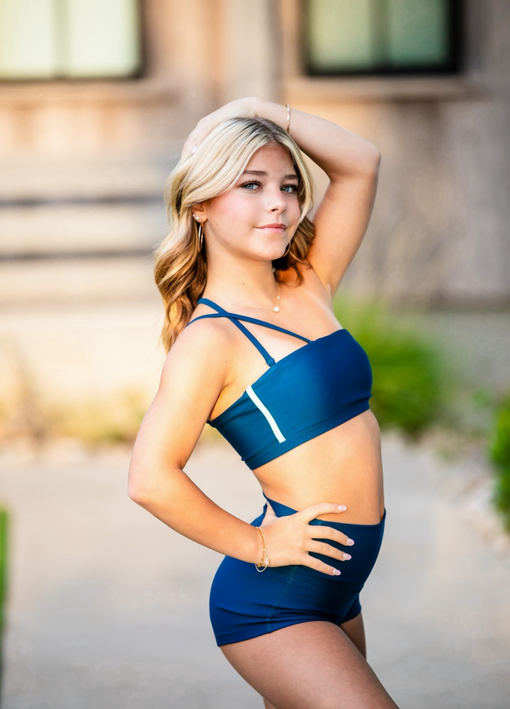 Woman wearing a blue sports bra and shorts outdoors