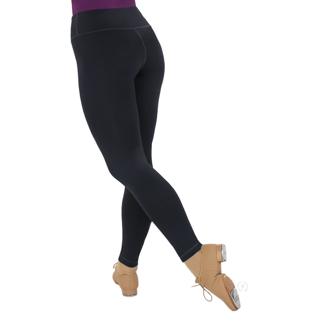 Black leggings worn by a person with beige dance shoes on a white background