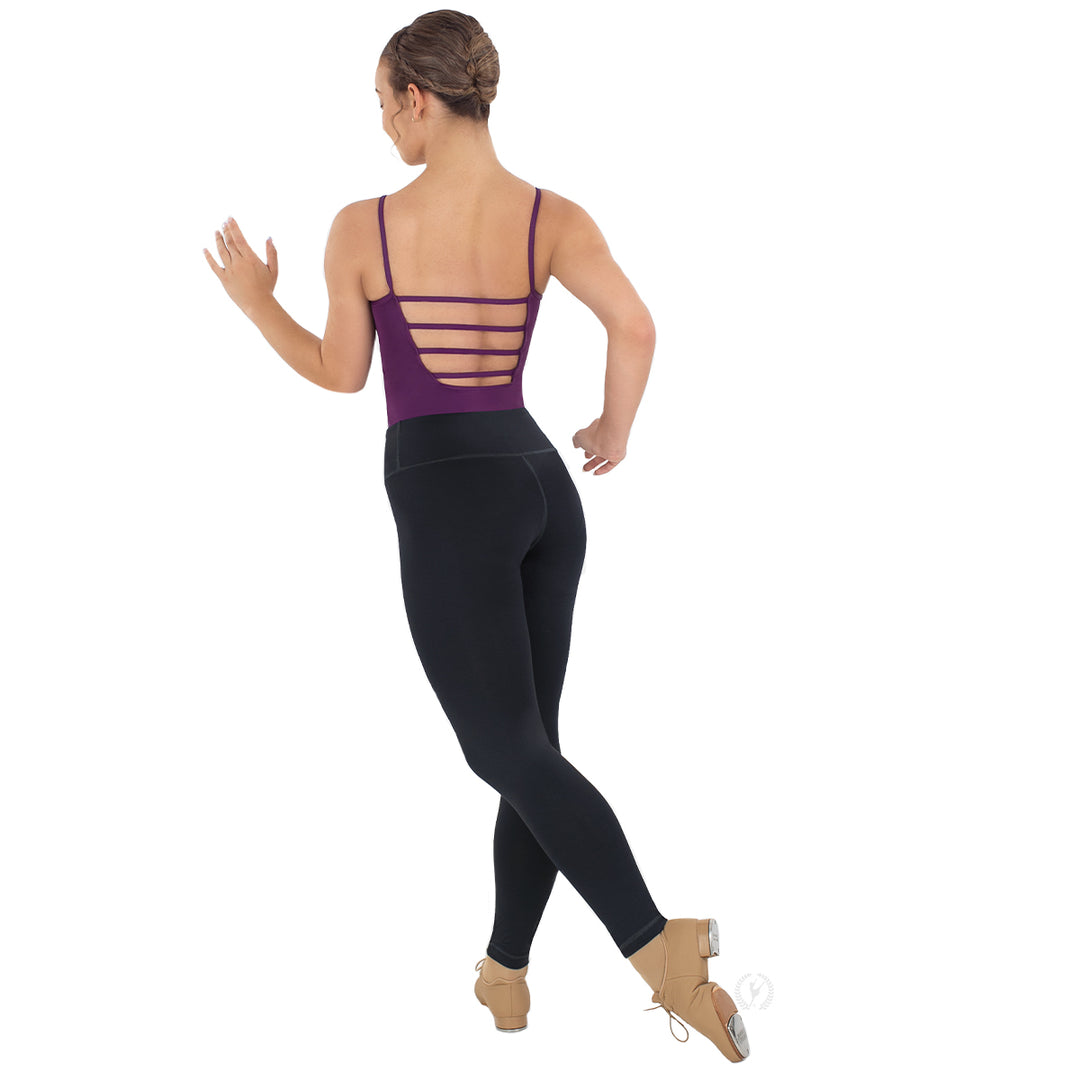 Dancer wearing a purple leotard with cut-out design and black leggings on a white background