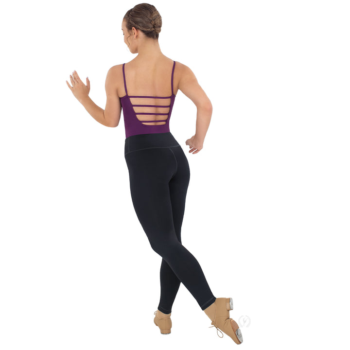 Dancer wearing a purple leotard with cut-out design and black leggings on a white background