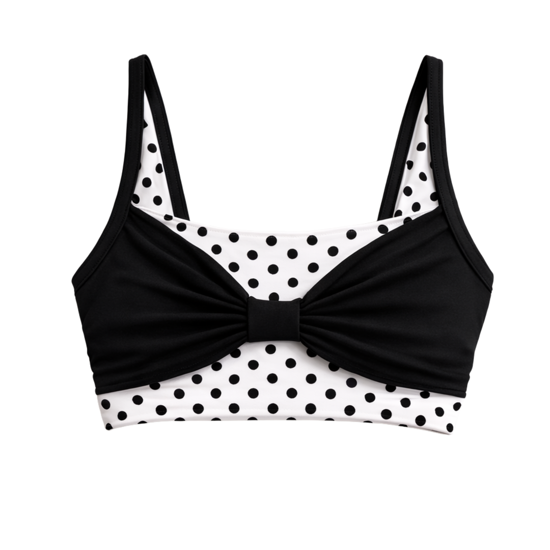 Black and white polka dot bikini top with a bow detail on a white background