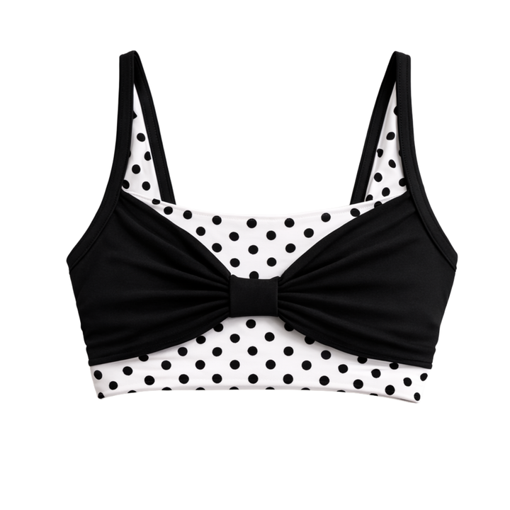 Black and white polka dot bikini top with a bow detail on a white background