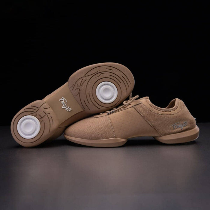 Pair of brown dance shoes with white soles on a dark background