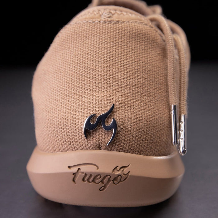 Beige sneaker with a flame logo and 'Fuego' branding on a dark background