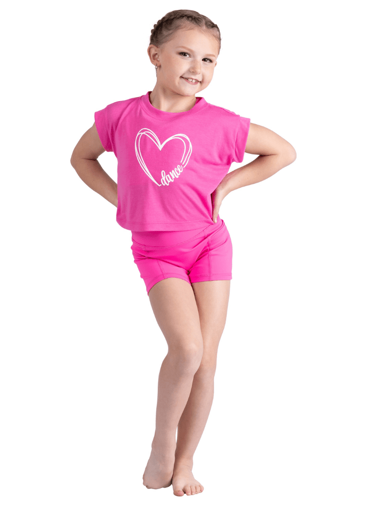 Young girl wearing a pink outfit with a heart design on a white background