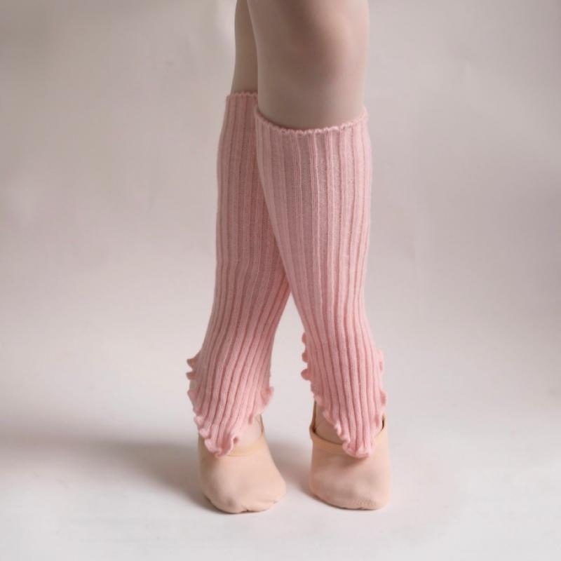 Pink ribbed leg warmers worn by a child on a plain background