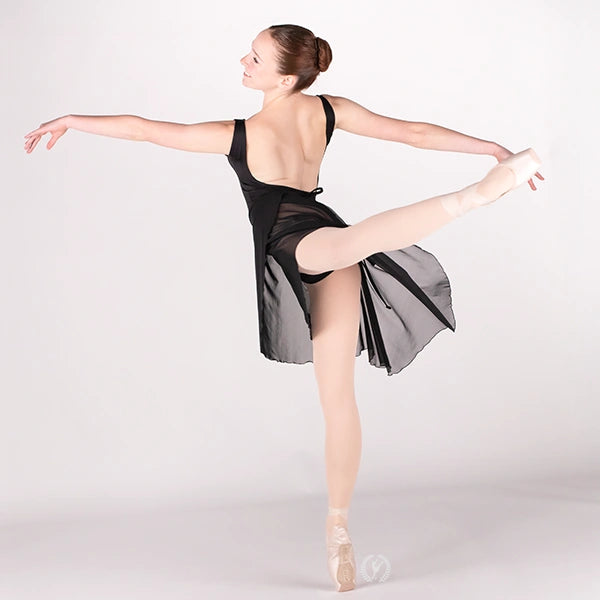 Ballerina in a black leotard and skirt posing on a white background