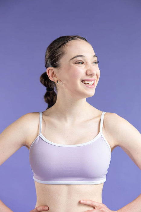 Woman wearing a light purple sports bra against a purple background