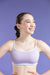 Woman wearing a light purple sports bra against a purple background