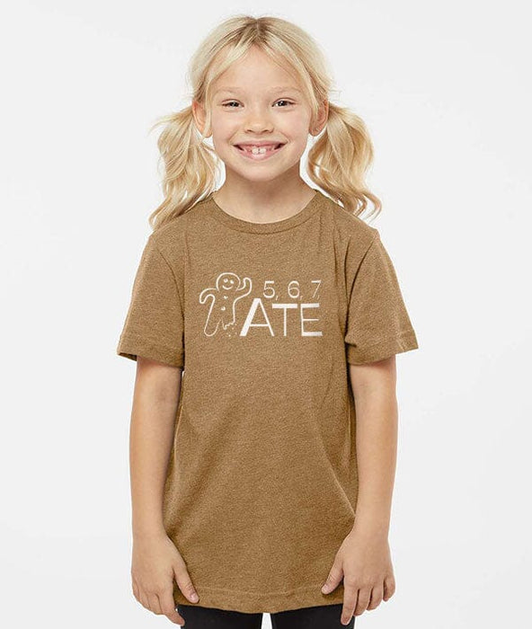 Young girl wearing a brown t-shirt with a graphic design on a white background