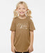 Young girl wearing a brown t-shirt with a graphic design on a white background