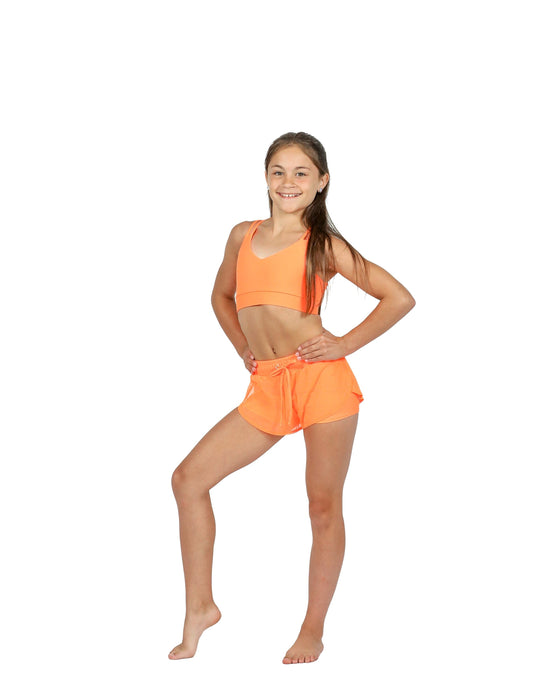 Girl wearing an orange sports outfit on a white background