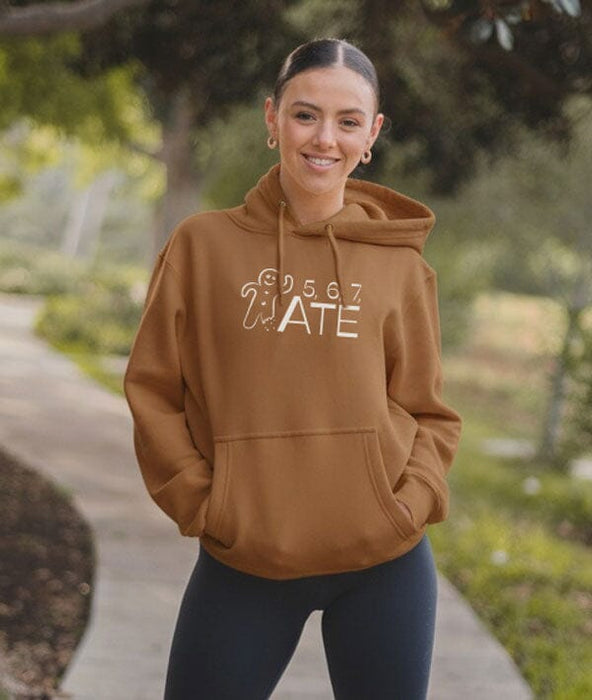 Woman wearing a brown hoodie with text and graphics outdoors