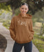 Woman wearing a brown hoodie with text and graphics outdoors