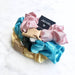 Set of colorful scrunchies with a brand card on a white background
