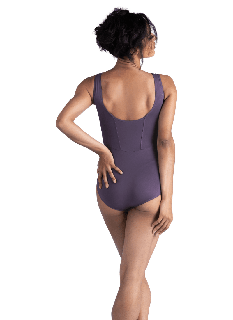 Woman wearing a purple leotard on a white background
