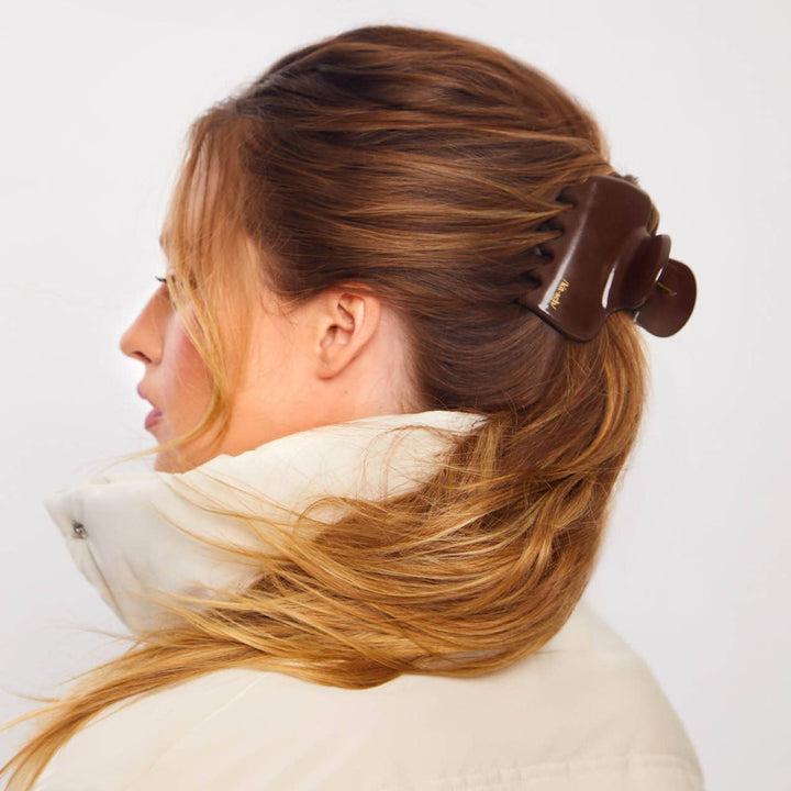 Woman with hair styled using a hair roller on a white background