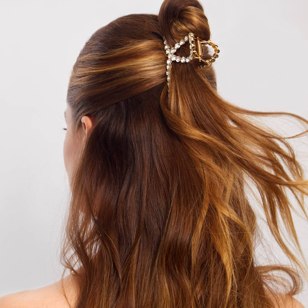Woman with styled hair featuring a decorative hair clip on a plain background