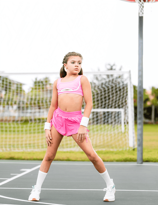 Person in pink athletic outfit on a tennis court