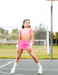 Person in pink athletic outfit on a tennis court