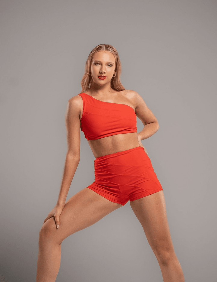 Woman wearing a red outfit posing against a gray background