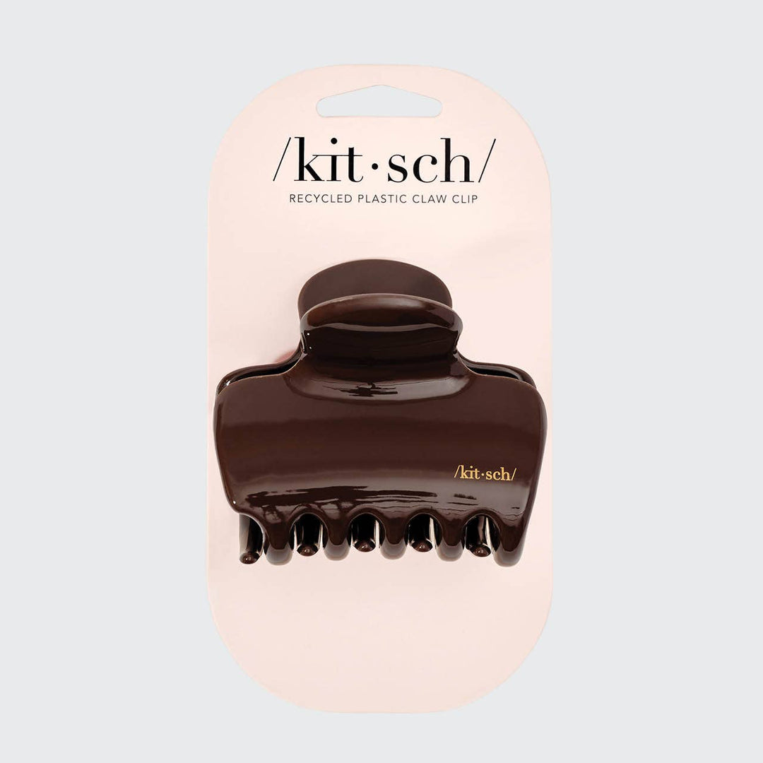 Brown claw clip on a 'kit-sch' branded pink card against a light gray background