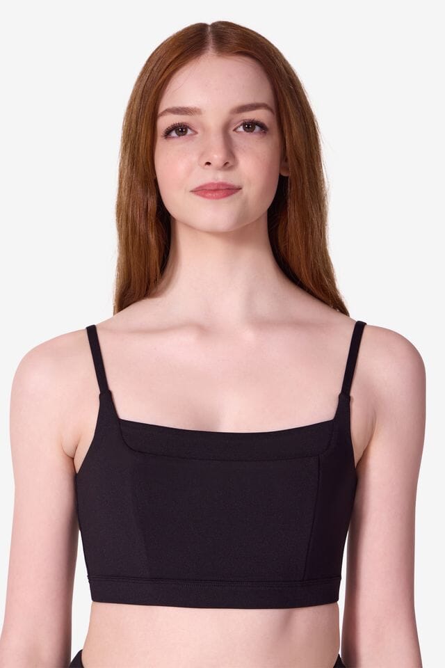 Woman wearing a black sports bra against a white background