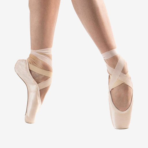 Ballet shoes with sheer straps worn by a dancer on a white background