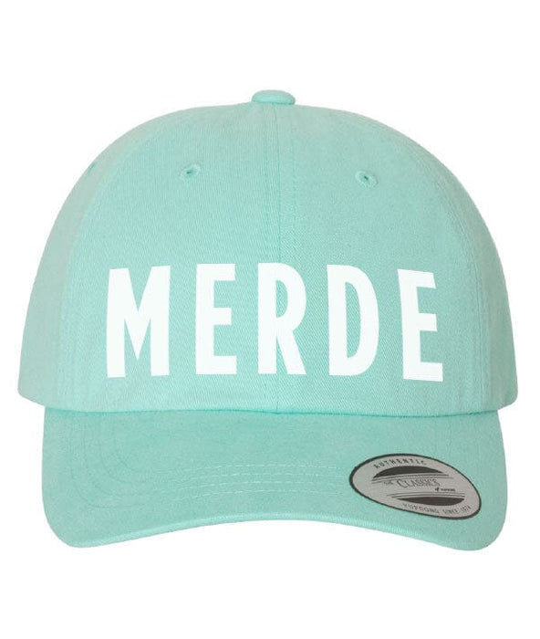 Mint green cap with 'MERDE' printed on it against a white background