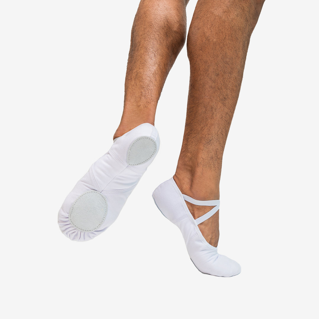 White ballet shoes with gray soles worn by a person on a white background