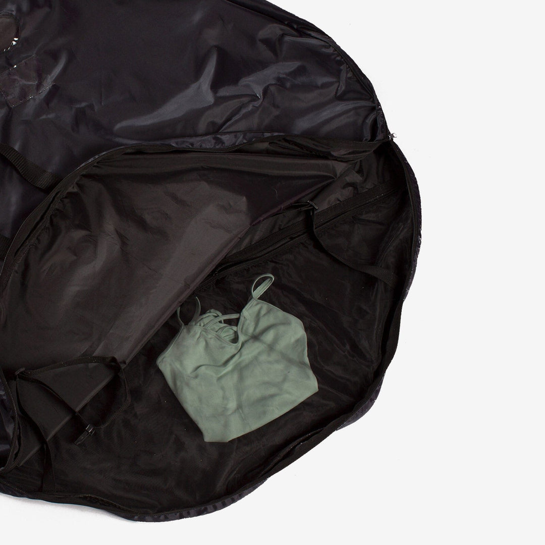 Black garment bag with a green drawstring bag inside on a light gray background