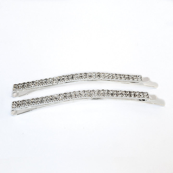 Two silver hair clips with clear rhinestones on a white background
