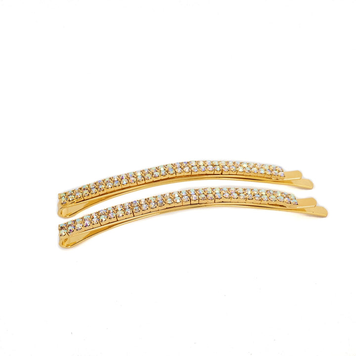 Two gold hair clips with crystal embellishments on a white background