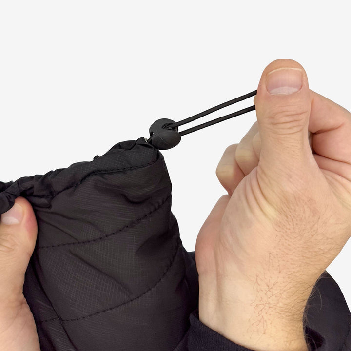 Person adjusting a black drawstring on a product against a white background