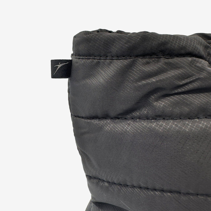 Close-up of a gray quilted jacket with a brand label on a white background