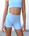 Light blue athletic top and shorts on a person against a neutral background