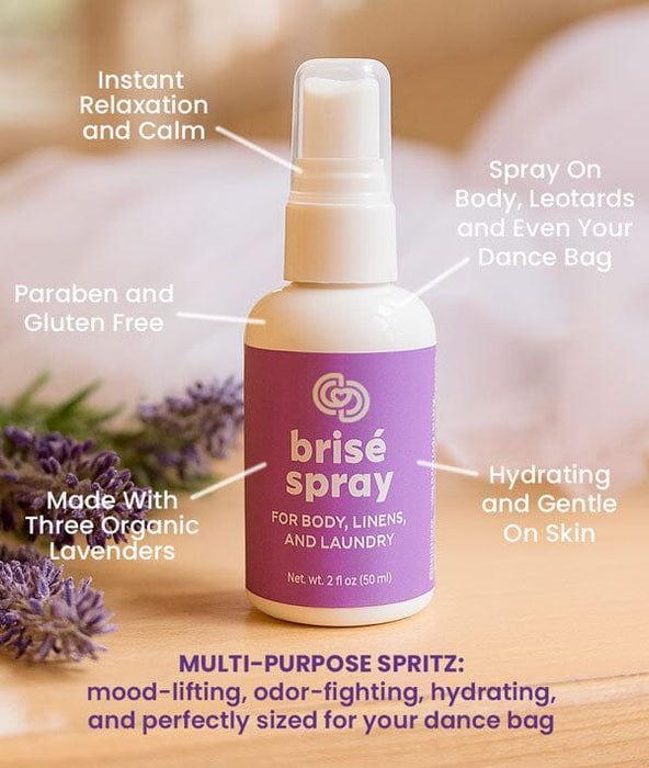 Brisé spray bottle with features labeled on a wooden surface with lavender flowers.
