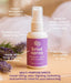 Brisé spray bottle with features labeled on a wooden surface with lavender flowers.