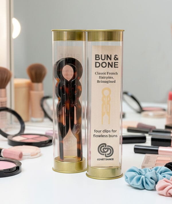 Bun & Done hairpin packaging on a makeup table with brushes and products.