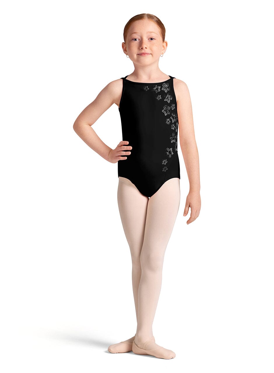 Young girl in a black leotard with floral patterns on a white background