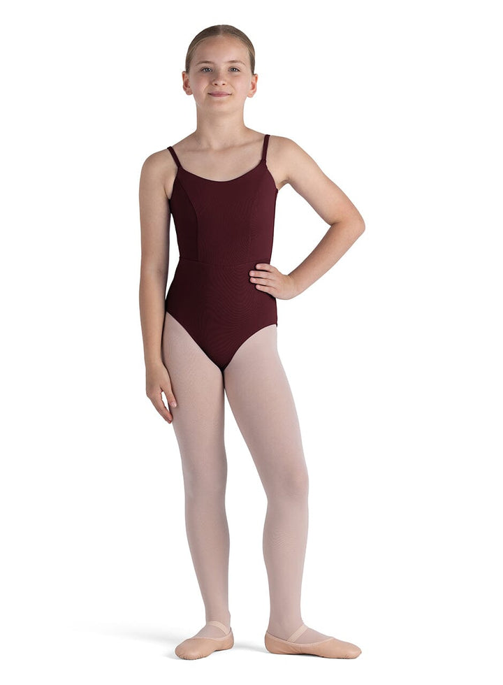 Young girl wearing a maroon leotard on a white background