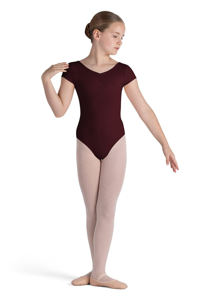 Ballet dancer wearing a maroon leotard on a white background