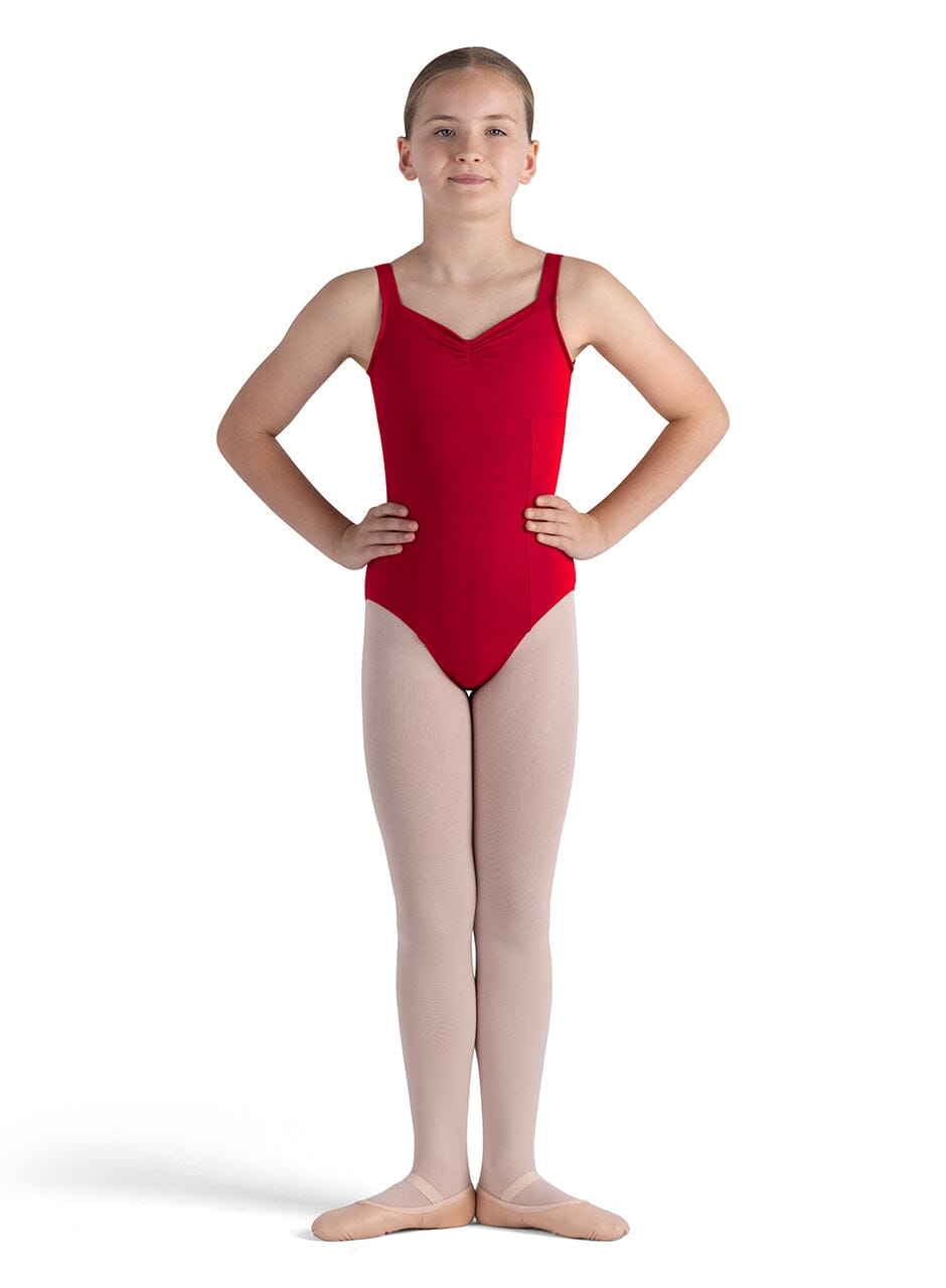 Young girl wearing a red leotard and beige tights on a white background