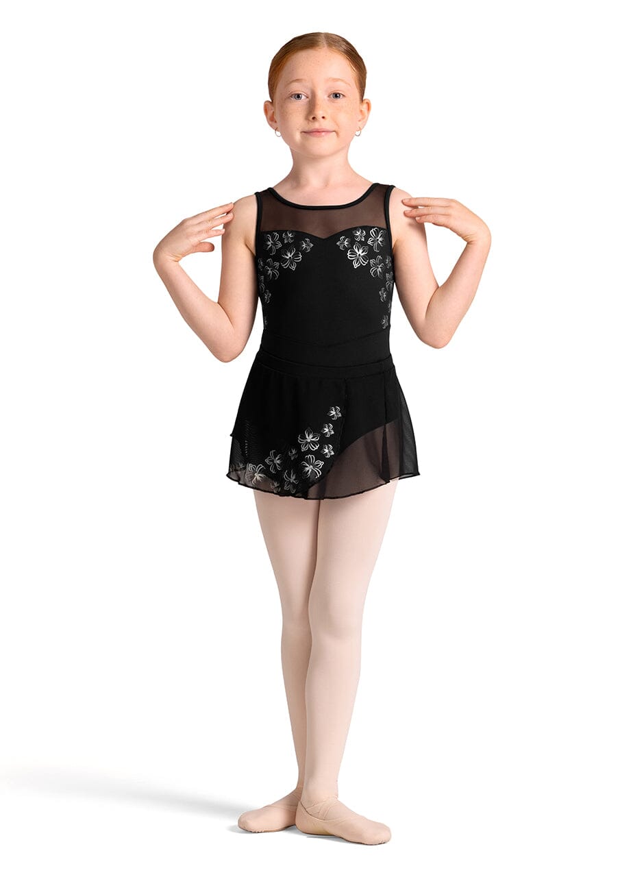 Young girl wearing a black ballet dress with floral embroidery on a white background