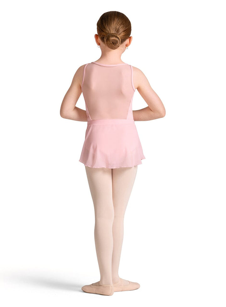Young girl in a pink ballet outfit standing on a white background