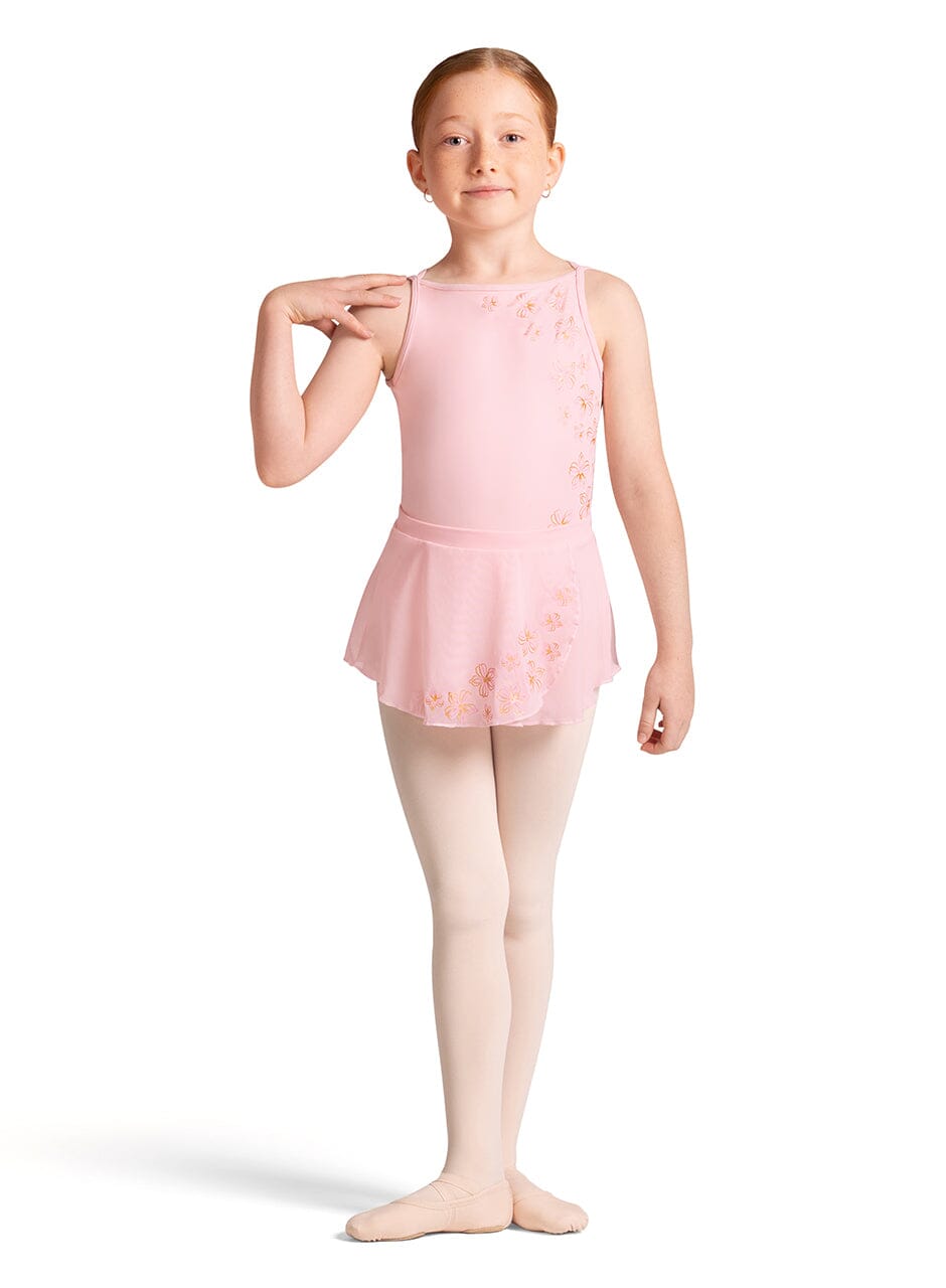 Young girl in a pink ballet outfit with a floral pattern on a white background