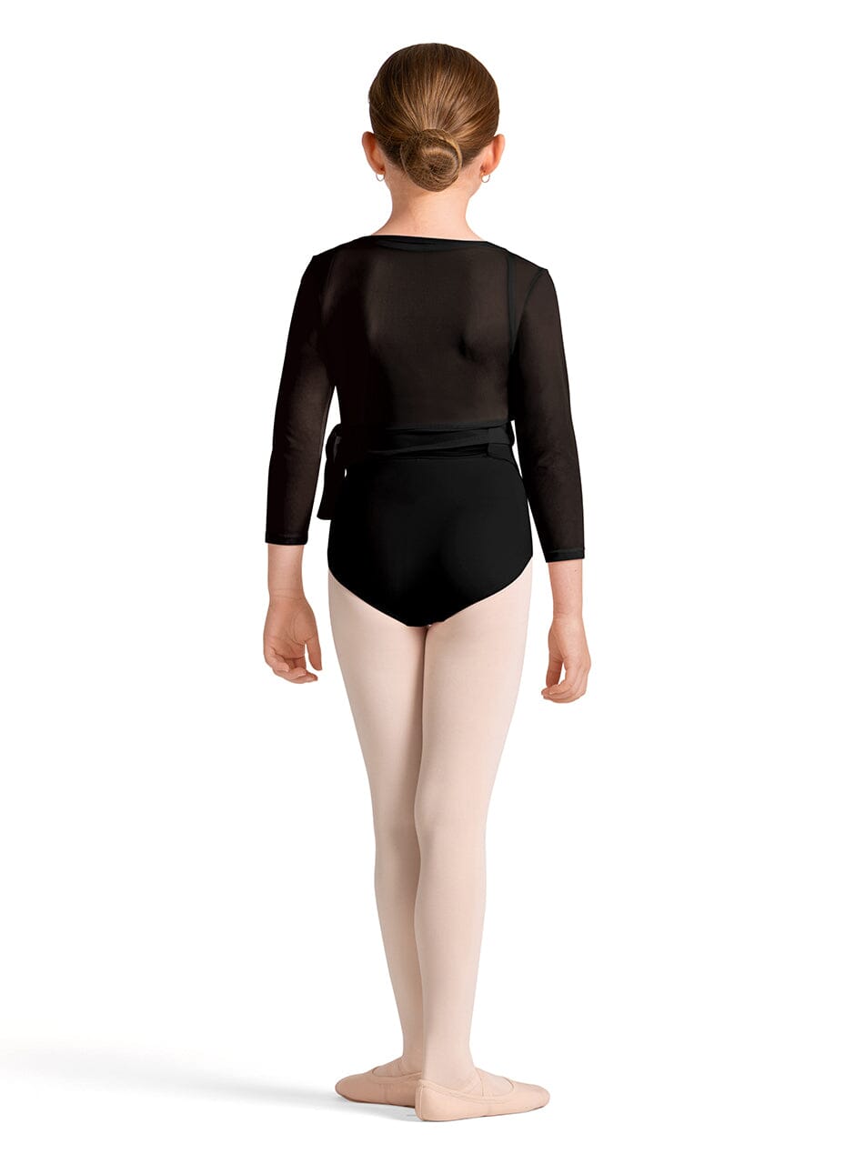 Young dancer wearing a black leotard and beige tights on a white background